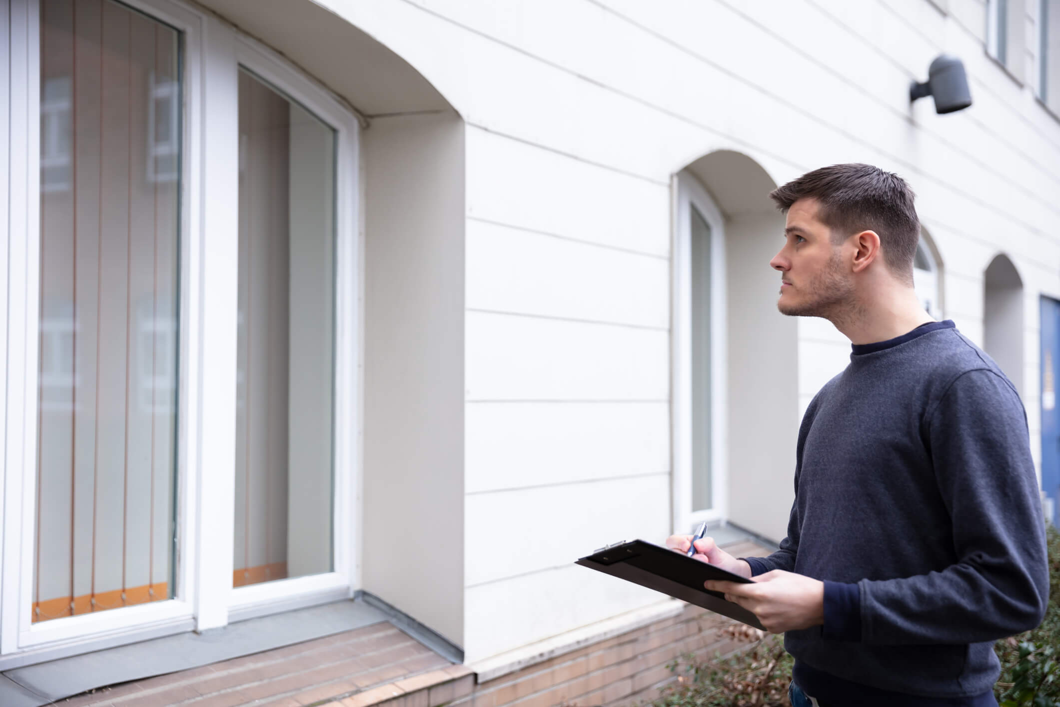 Landlord in Riviera Beach, FL inspects outside of property for tenant damage